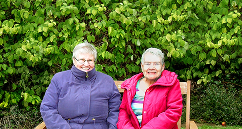 Two elderly women sitting on a park bench
