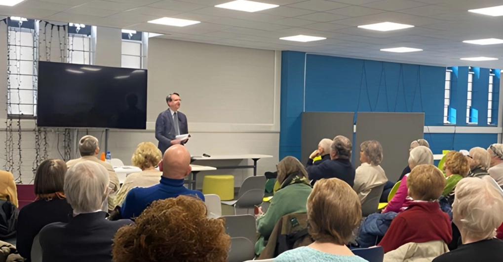Community gathering with man speaking to diverse audience