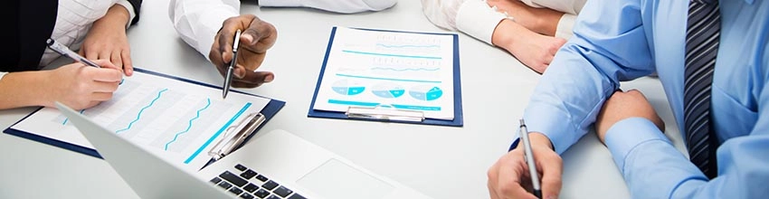 Group of students working together with charts and laptop