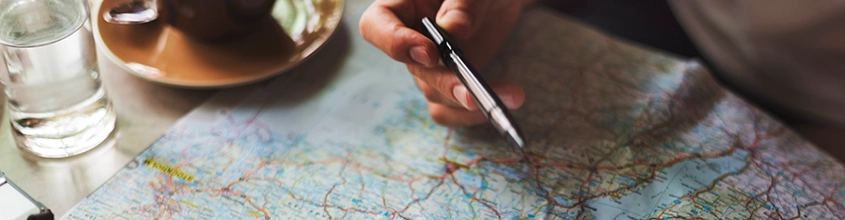 Someone holding a pen over a map