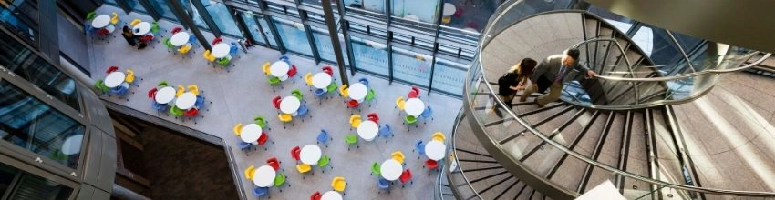 A view of people on the ground floor of the Trinity School of business building viewed from the 4th floor