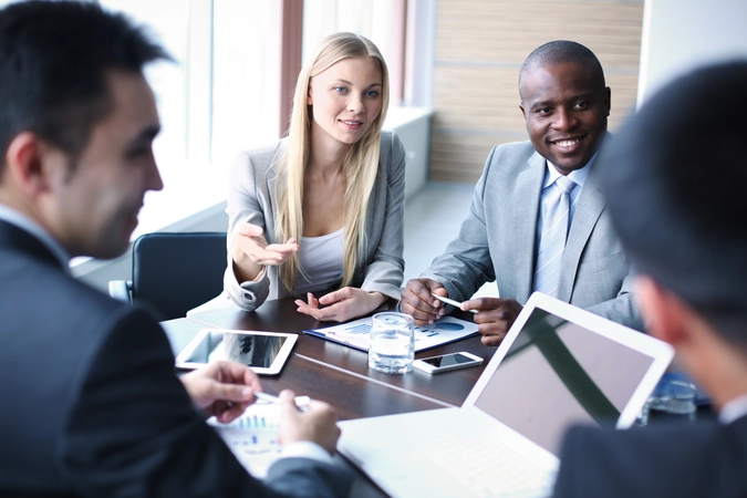 Four people sitting at a table during a business meeting