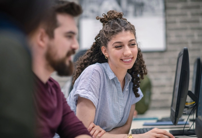 One male and one female student looking at a laptop together