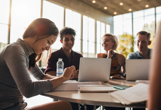 Four students working together at a table at sundown