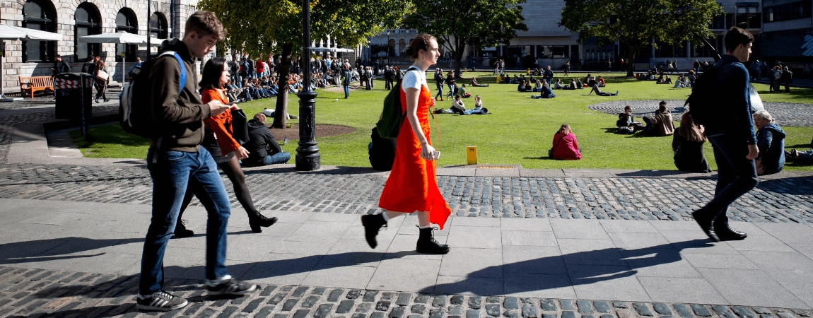 Students walking across Trinity campus on a sunny day