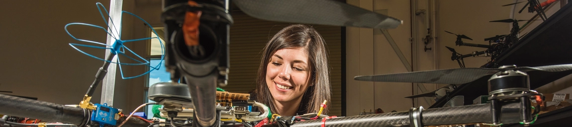 A person working on a machine with several propellers