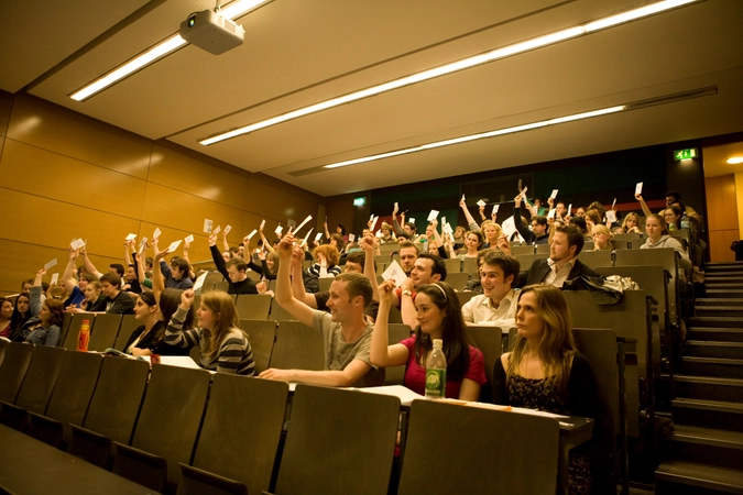 Group of students holding up cards in a lecture theatre.