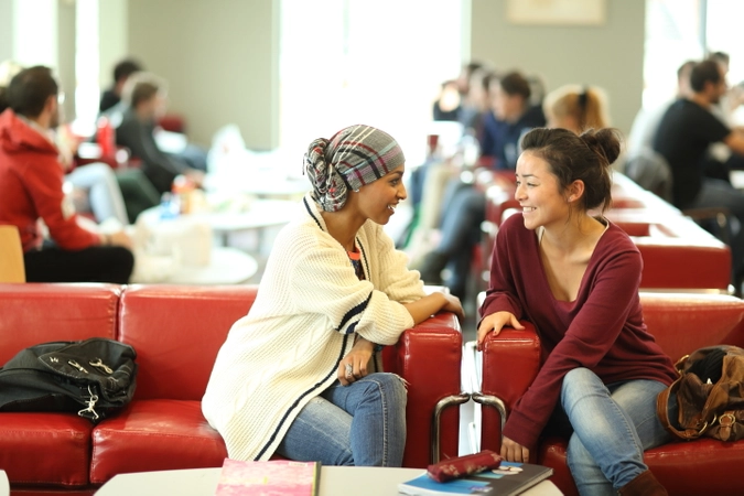 Two students sitting on couches in the Trinity Biomedical Sciences Institute canteen