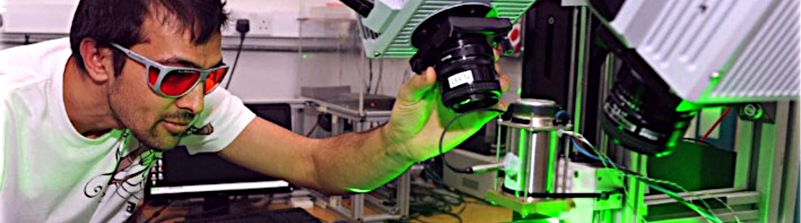 A student refocusing a microscope