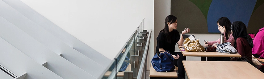 three asian students sitting in a modern building