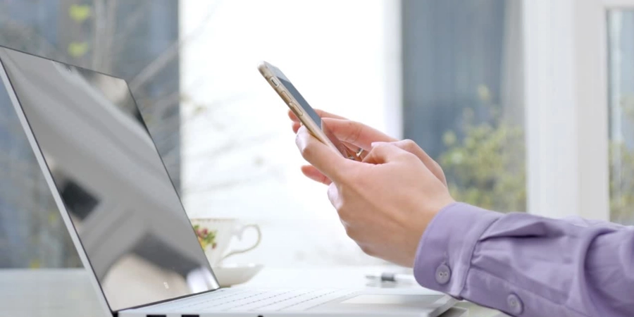 A person using laptop and phone