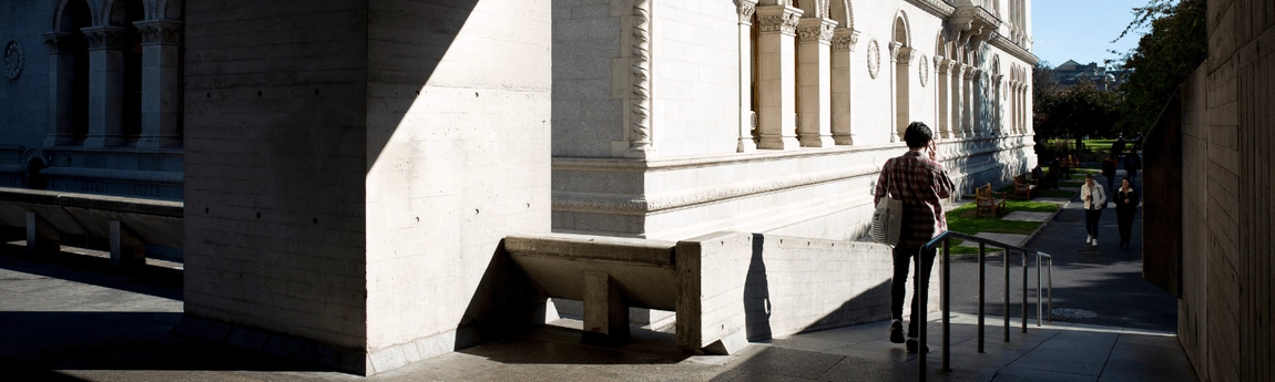 A student walking down a ramp from the Boland Library.