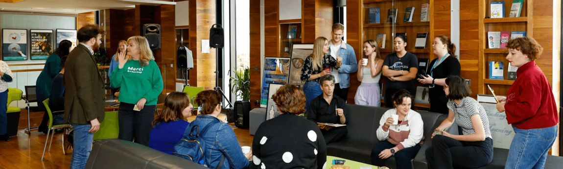 A group of people in conversation in the Long Room Hub