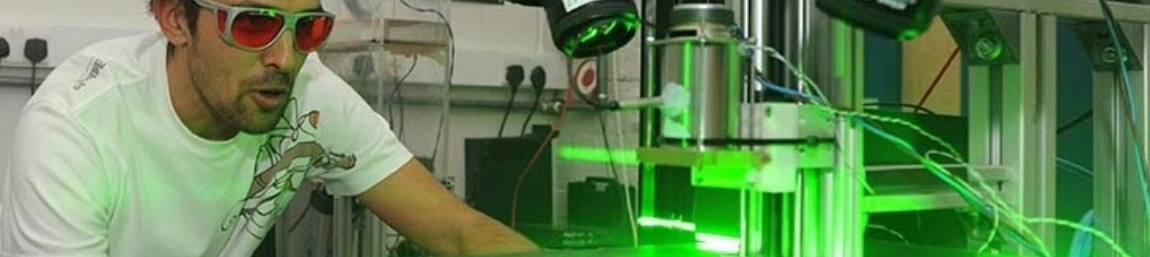 An image of a person working on a machine that uses lasers