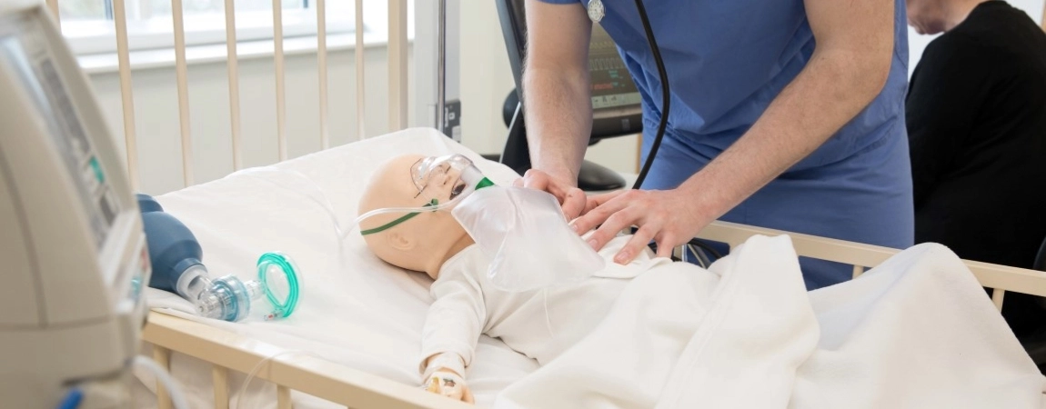 A doctor carrying out CPR training on a Dummy baby