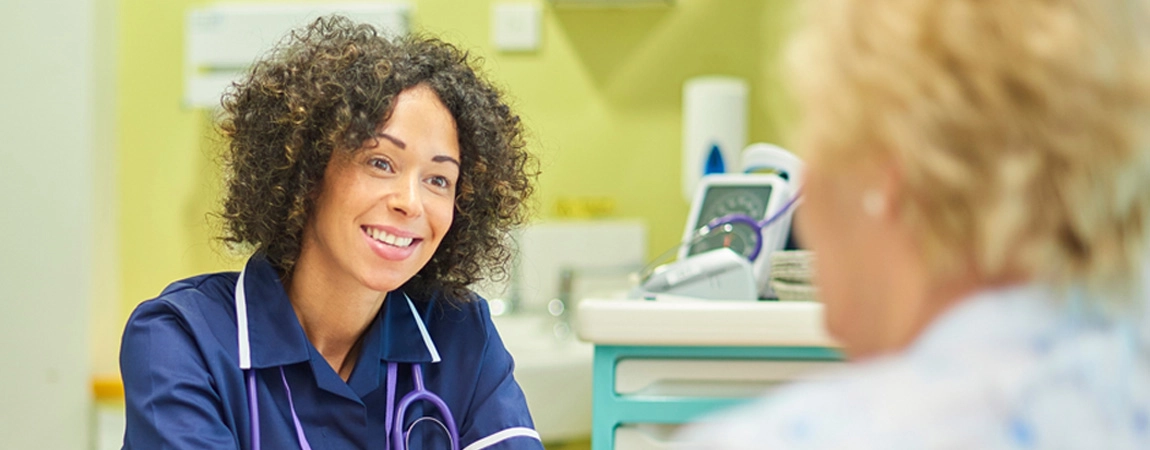 Smiling nurse talking with patient