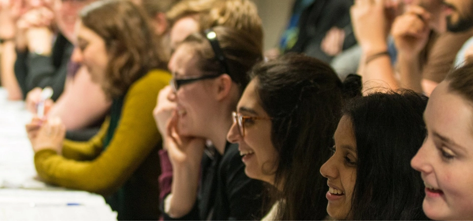 Image of women in Physics with young women students in a lecture hall