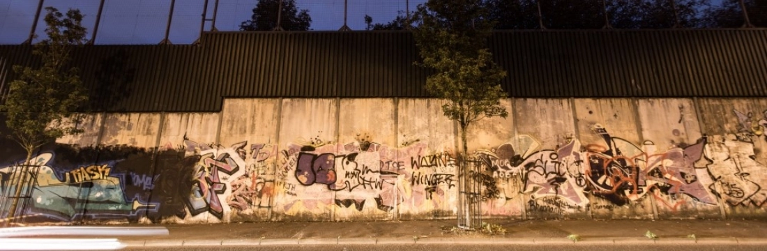 A wall by a road at night time