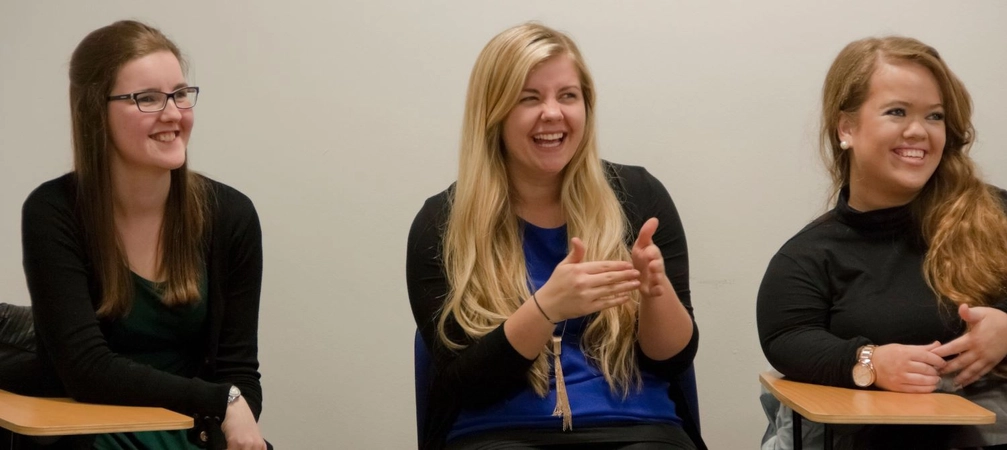3 students applauding.