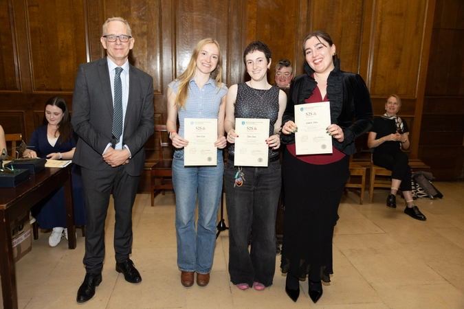 man in suit beside three volunteers all holding a certificate each