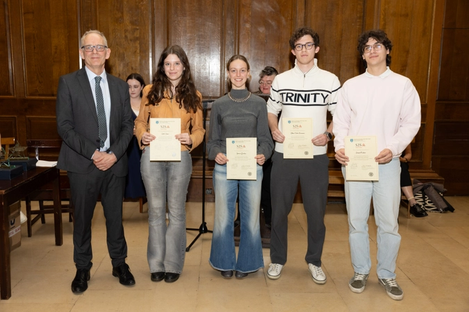 man in suit standing beside four volunteers, all holding certificates