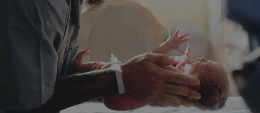 Nurse holding baby in neonatal ward