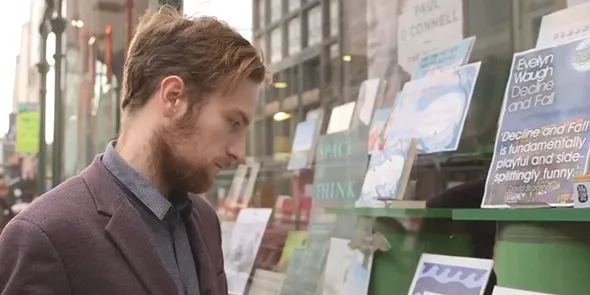 A person looking in the window of a bookshop