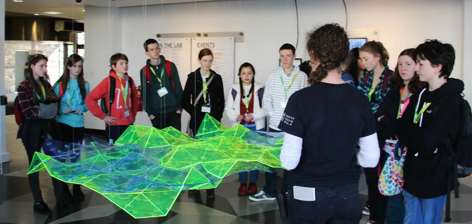 Image of the Trinity Walton Group with students observing a 3D Physics related model