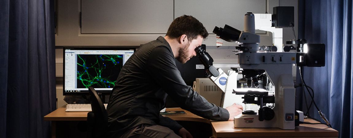 Man looking into microscope