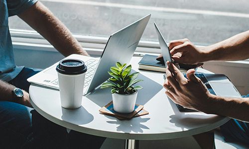 Two people sitting with laptops