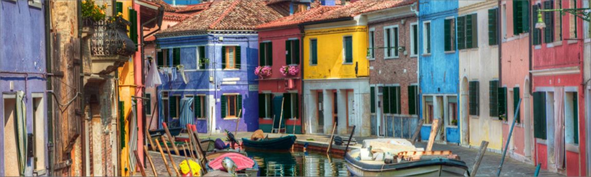 Vibrant houses on a canal with boats in Italy