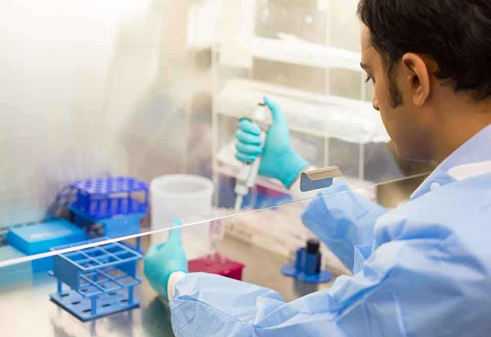 A student using a pipette to carry out an experiment