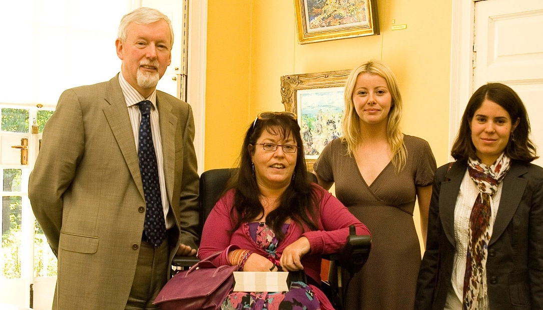 woman in a wheelchair with a man and a woman standing beside her