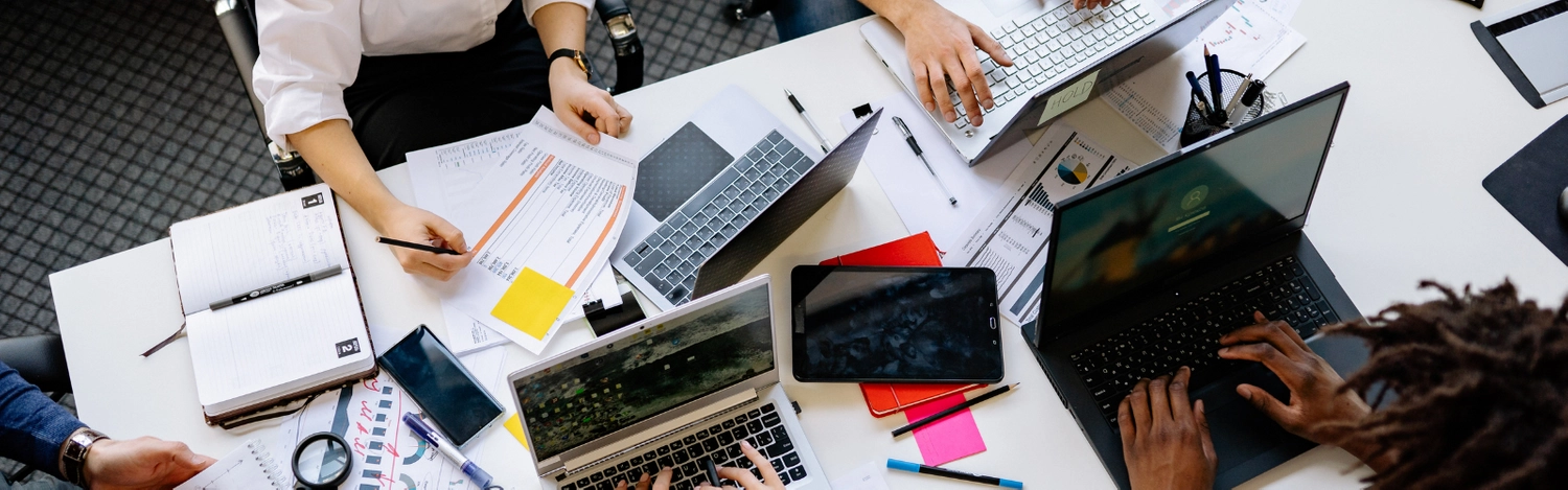 aerial image of a desk with computers and professionals working