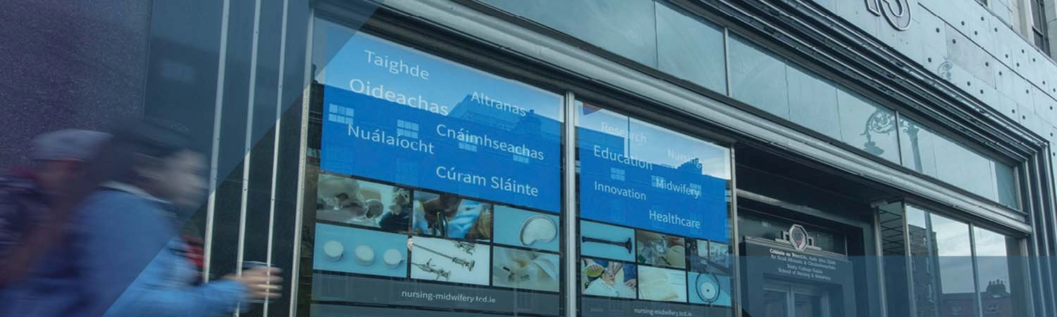 Exterior of the School of Nursing and Midwifery with person walking into the shot