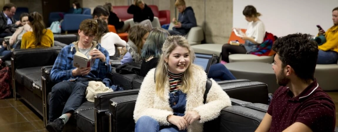 Students sitting chatting in the arts building Trinity College Dublin
