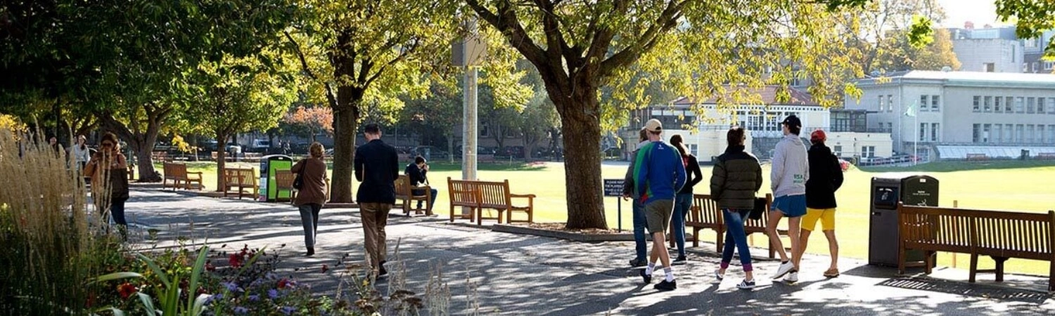 Students walking beside the Cricket pitch at Trinity College Dublin