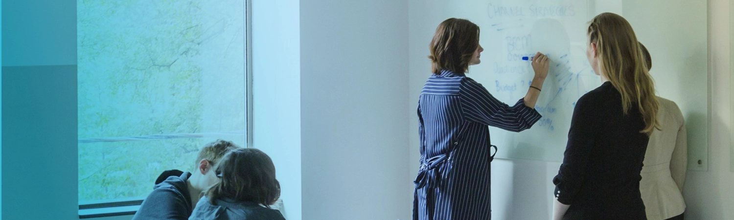 Four people at a white board during a meeting