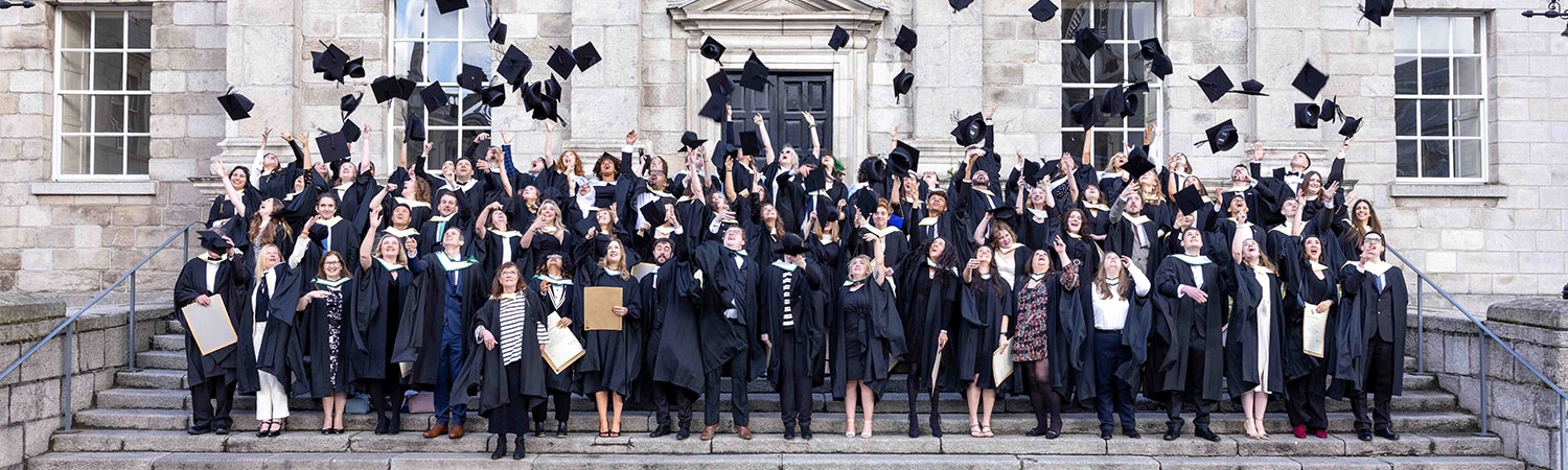 Graduates throwing cap and gown in air