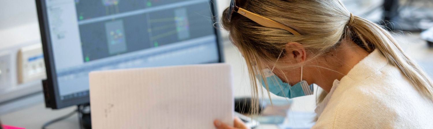 A student studying in front of a monitor wearing a face covering
