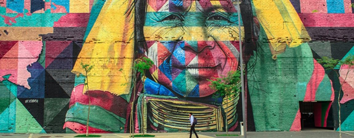A mural on a wall with a man walking past it