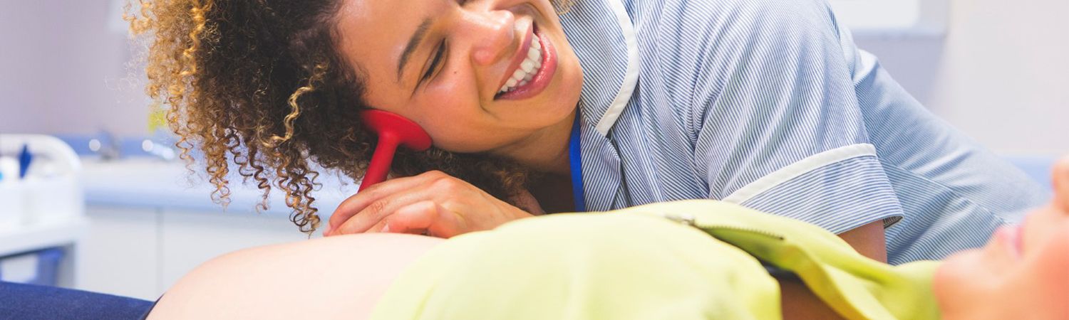 Nurse checking belly of pregnant woman