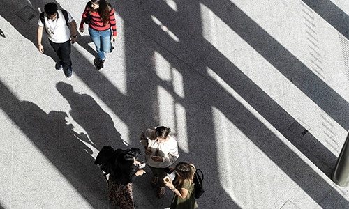 Aerial view of 5 students walking on a concrete walkway