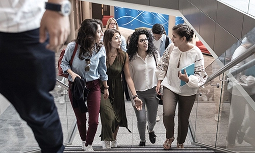 Students climbing a staircase in modern building