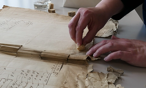 A hand working with an ancient text