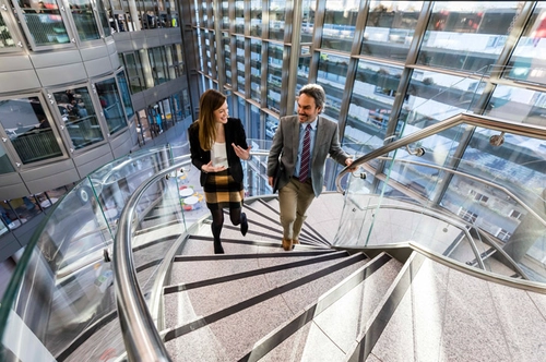 Two business staff walking up the stairs in the Business Centre at Trinity College Dublin