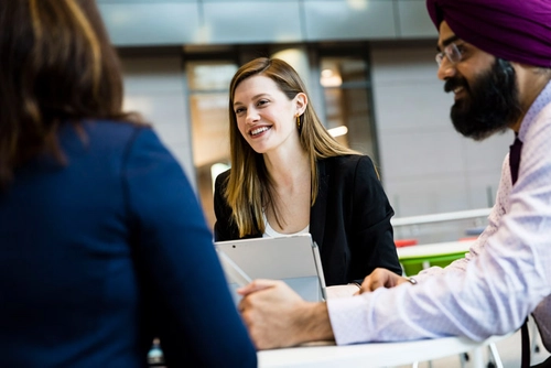 An image of graduates in conversation during a task