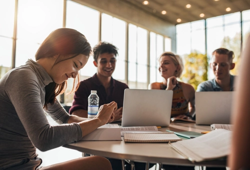 Four students working together at a table at sundown