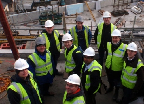 Group of workmen in hard hats and high vis vest