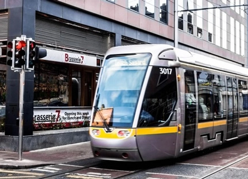A photo of the Luas driving past a shop called 'Brasserie 7'